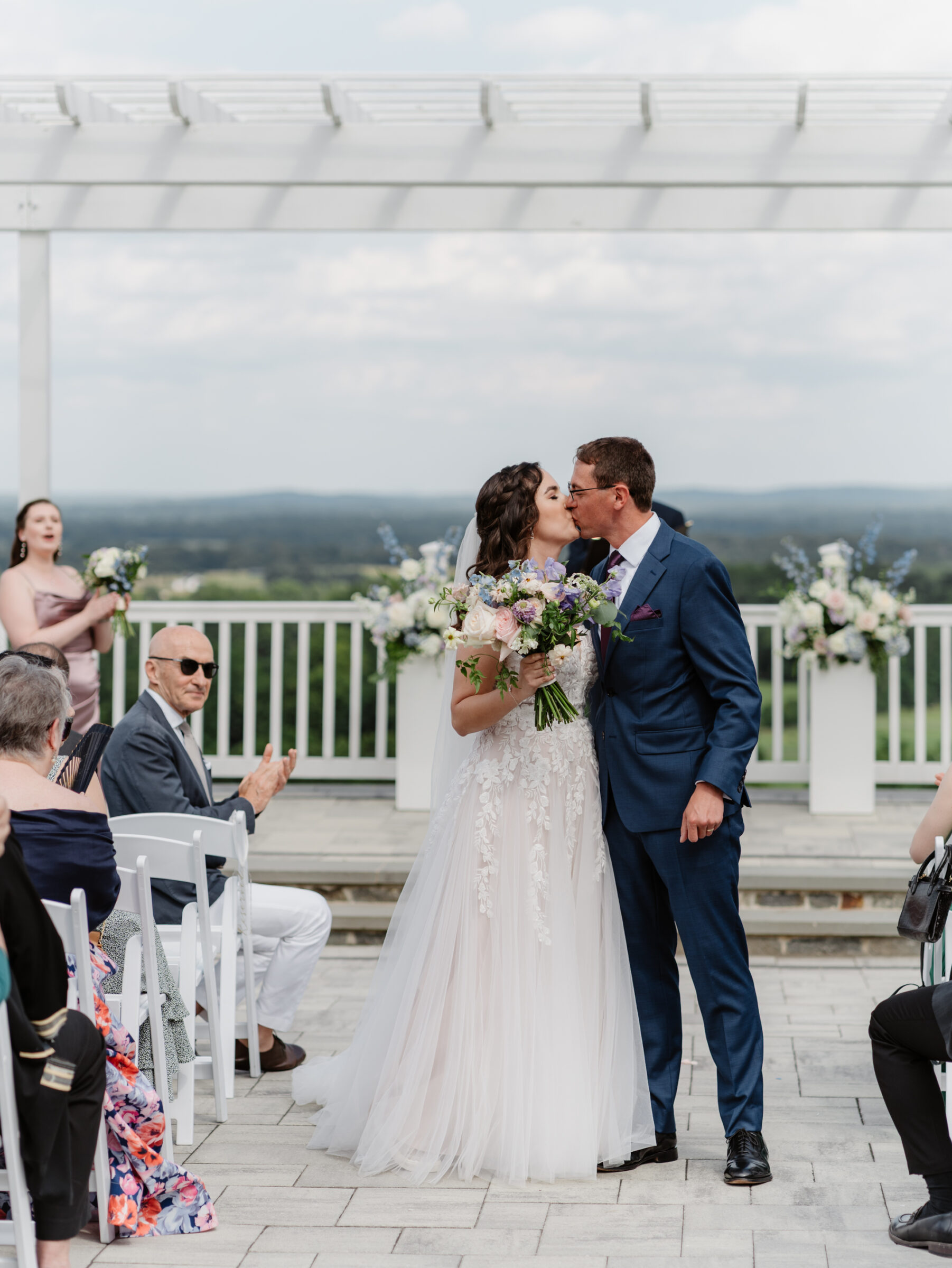 Couple sharing their first kiss during a scenic Bluemont VA wedding ceremony with mountain views